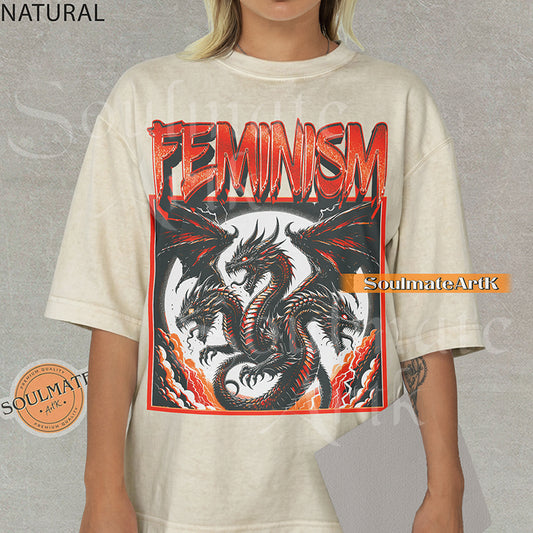 Illustration of a multi-headed red and black dragon in a framed graphic with bold red text reading Feminism on a natural shirt.