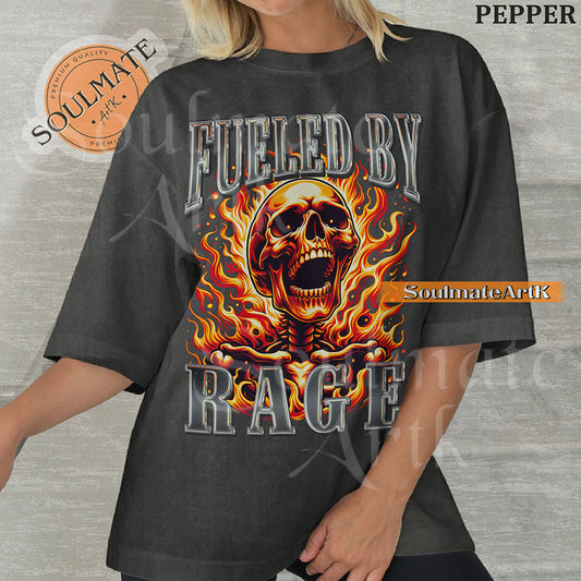 Graphic of a screaming skull engulfed in orange flames with bold chrome 3D text reading FUELED BY RAGE on a washed pepper shirt.