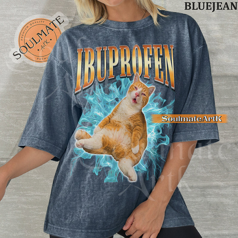 Orange tabby cat with a confused expression surrounded by blue lightning with bold orange gradient text reading Ibuprofen on a washed bluejean shirt.