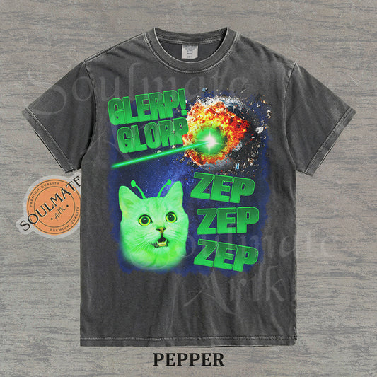Graphic of a glowing green cat with antennae in space next to an exploding planet and text reading Glerp Glorp Zep Zep Zep on a washed pepper shirt.