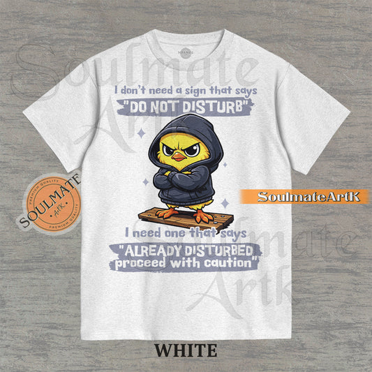 A funny t-shirt featuring a cute baby chick wearing a hoodie with a grumpy expression. The text reads "I Don't Need A Sign That Says Do Not Disturb I Need One That Says Already Disturbed Proceed With Caution."