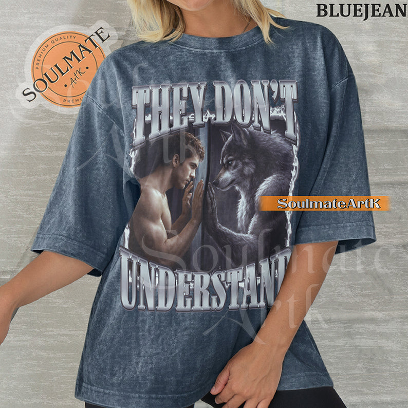 Cinematic graphic of a shirtless man and a wolf facing each other through a window with bold silver text reading They Don't Understand on a washed bluejean shirt.