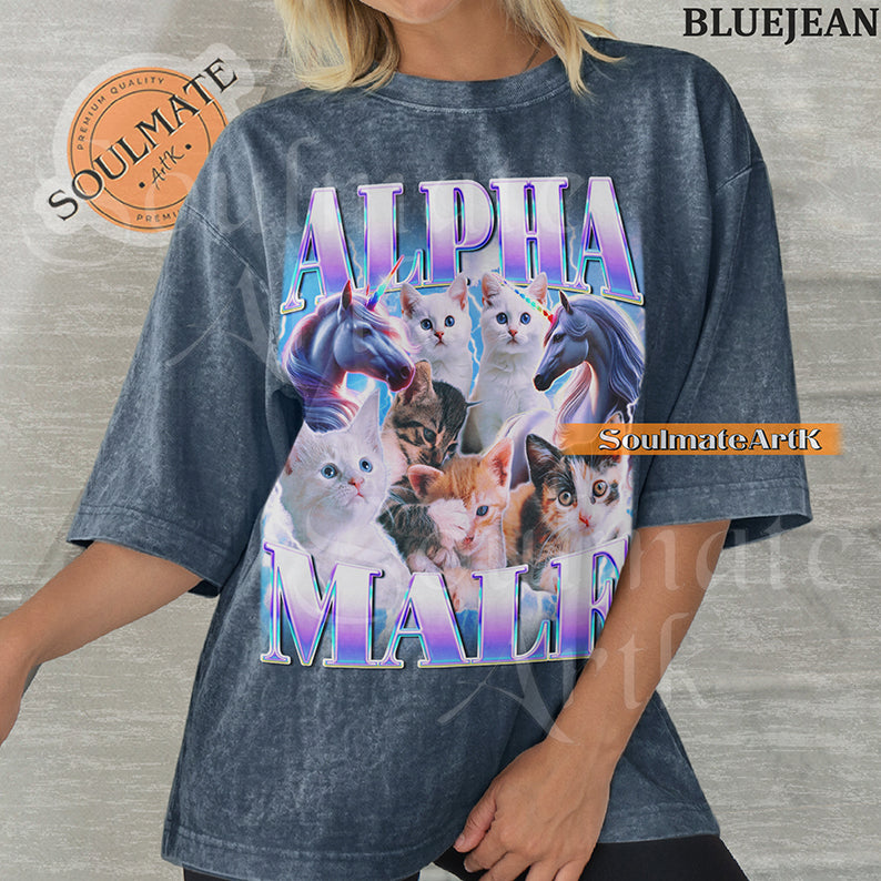 Collage of several cute kittens and two unicorns surrounded by blue lightning with bold purple and blue text reading Alpha Male on a washed bluejean shirt.