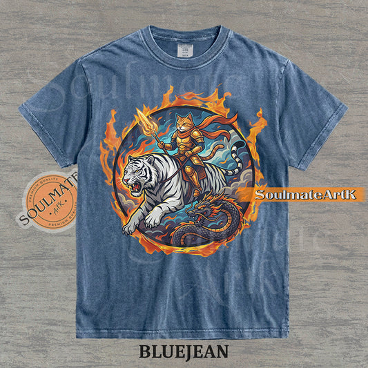 Illustration of an armored cat warrior riding a white tiger over a dragon, surrounded by a circle of fire on a washed bluejean shirt.