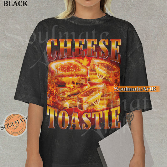 Graphic collage of melting grilled cheese sandwiches surrounded by flames with bold metallic text reading CHEESE TOASTIE on a washed black shirt.