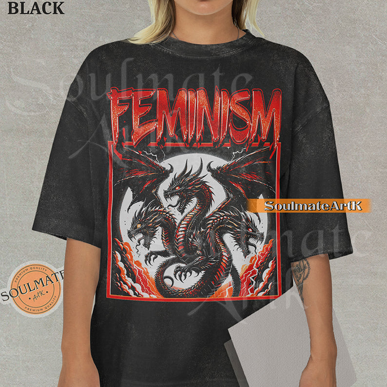 Illustration of a multi-headed red and black dragon in a framed graphic with bold red text reading Feminism on a washed black shirt.