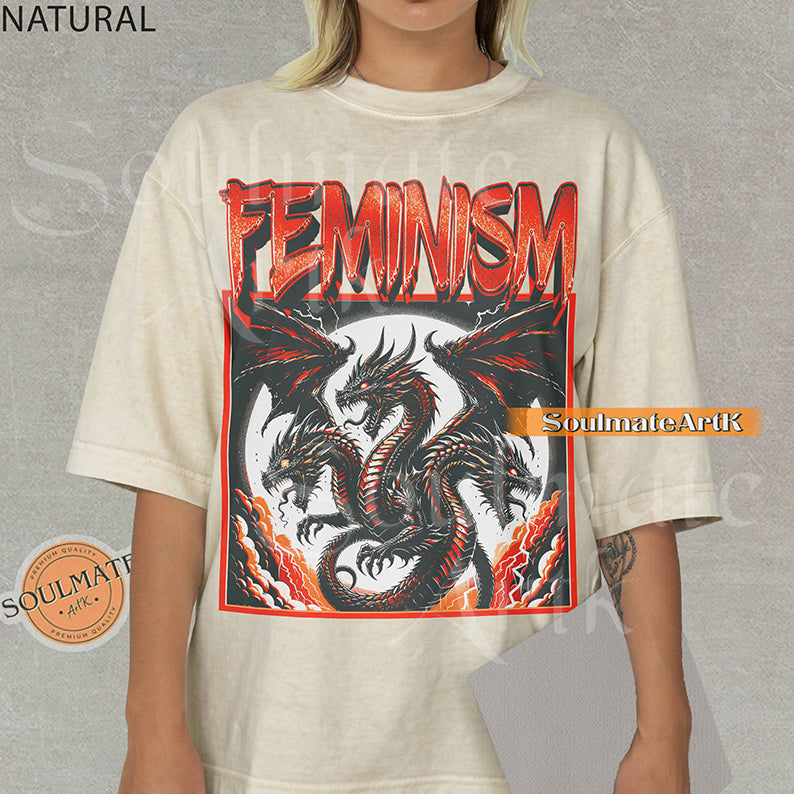 Illustration of a multi-headed red and black dragon in a framed graphic with bold red text reading Feminism on a natural shirt.