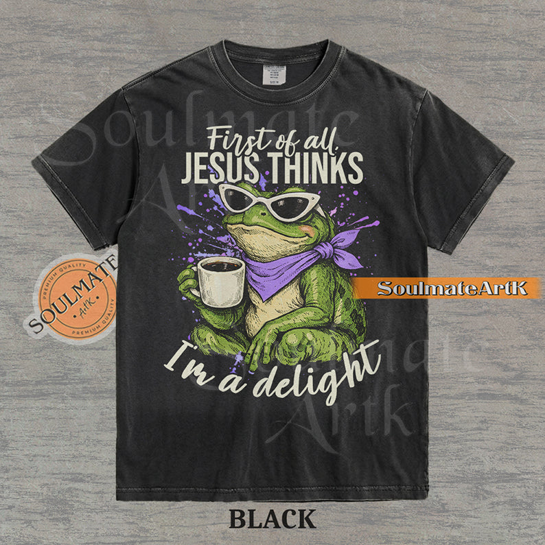 Illustration of a green frog in sunglasses and a purple scarf holding a coffee mug with the text "First of all, Jesus thinks I'm a delight" on a washed black shirt.