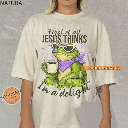 Illustration of a green frog in sunglasses and a purple scarf holding a coffee mug with the text "First of all, Jesus thinks I'm a delight" on a washed natural shirt.