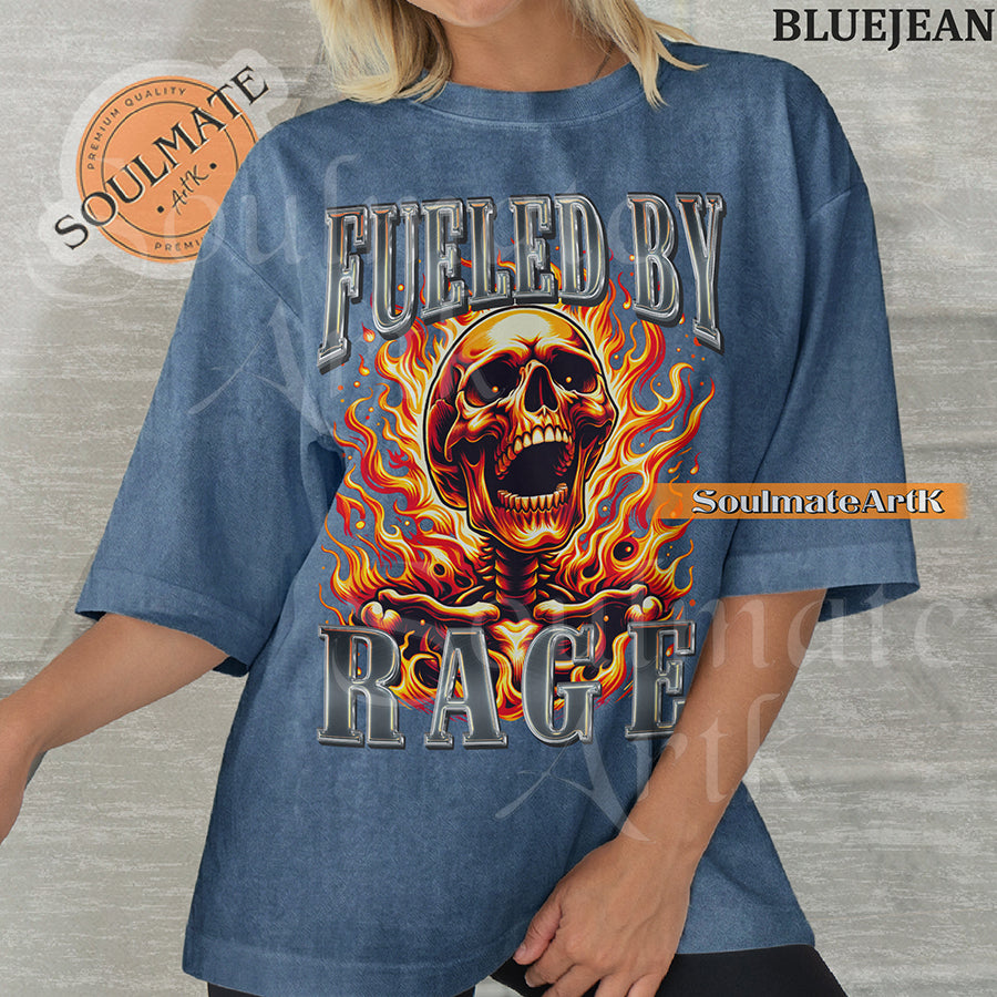 Graphic of a screaming skull engulfed in orange flames with bold chrome 3D text reading FUELED BY RAGE on a washed bluejean shirt.