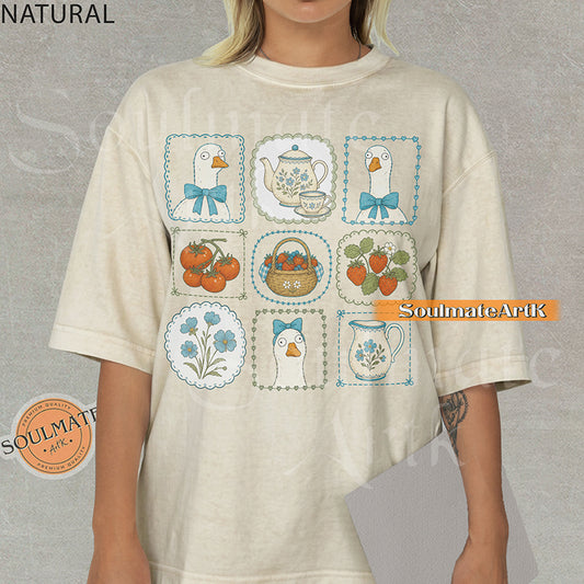 Cottagecore grid illustration featuring geese with bows, strawberries, tomatoes, and vintage teapots on a natural t-shirt.