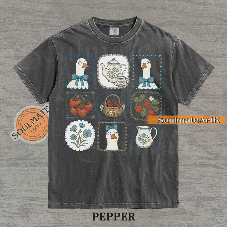 Cottagecore grid illustration featuring geese with bows, strawberries, tomatoes, and vintage teapots on a washed pepper t-shirt.