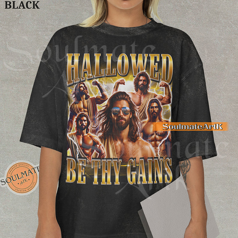 Vintage-style collage of a muscular man with a beard and sunglasses surrounded by lightning with bold gold metallic text reading Hallowed Be Thy Gains on a washed black t-shirt.