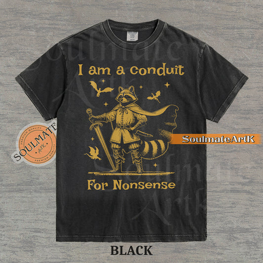 Illustration of a raccoon in knight armor with a cape and sword surrounded by dragons and the text "I am a conduit For Nonsense" on a washed black t-shirt.