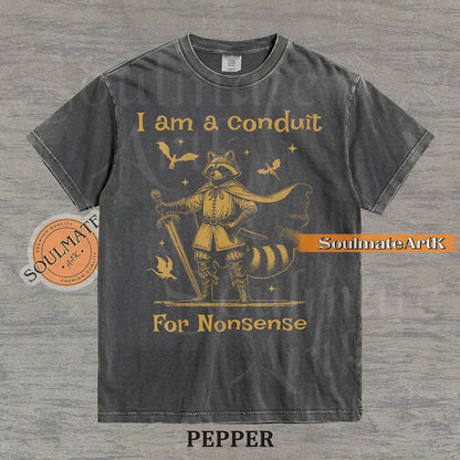 Illustration of a raccoon in knight armor with a cape and sword surrounded by dragons and the text "I am a conduit For Nonsense" on a washed pepper t-shirt.