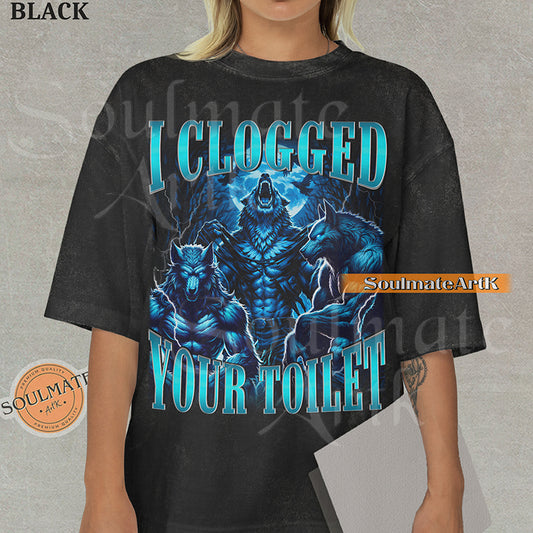 Vintage-style graphic of three muscular blue wolves howling at the moon with bold metallic text reading I Clogged Your Toilet on a washed black Comfort Colors t-shirt.