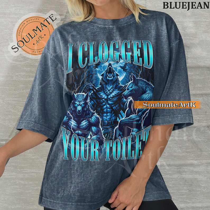 Vintage-style graphic of three muscular blue wolves howling at the moon with bold metallic text reading I Clogged Your Toilet on a washed Bluejean Comfort Colors t-shirt.