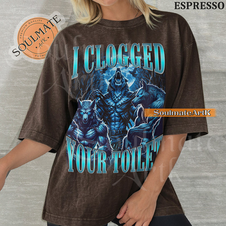 Vintage-style graphic of three muscular blue wolves howling at the moon with bold metallic text reading I Clogged Your Toilet on a washed espresso Comfort Colors t-shirt.