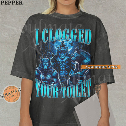 Vintage-style graphic of three muscular blue wolves howling at the moon with bold metallic text reading I Clogged Your Toilet on a washed pepper Comfort Colors t-shirt.