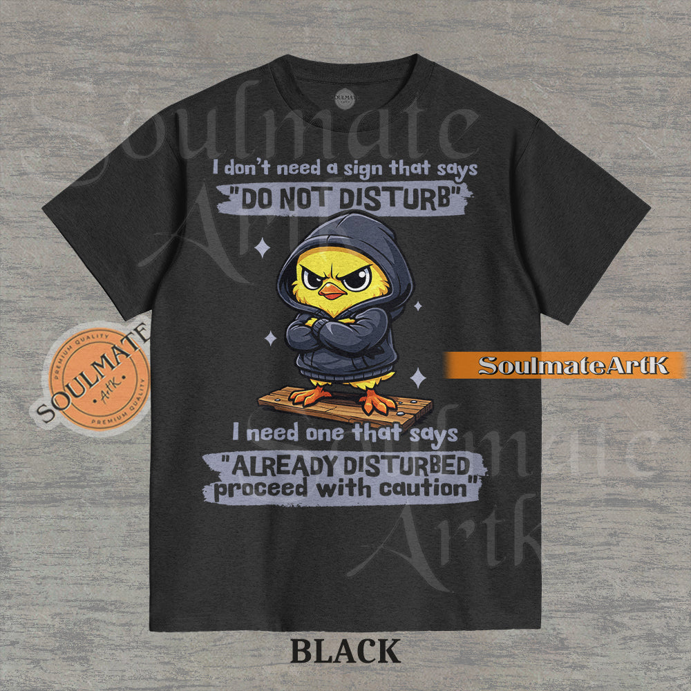 A funny t-shirt featuring a cute baby chick wearing a hoodie with a grumpy expression. The text reads "I Don't Need A Sign That Says Do Not Disturb I Need One That Says Already Disturbed Proceed With Caution."