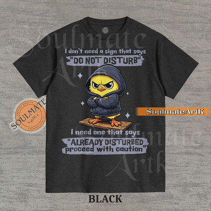 A funny t-shirt featuring a cute baby chick wearing a hoodie with a grumpy expression. The text reads "I Don't Need A Sign That Says Do Not Disturb I Need One That Says Already Disturbed Proceed With Caution."