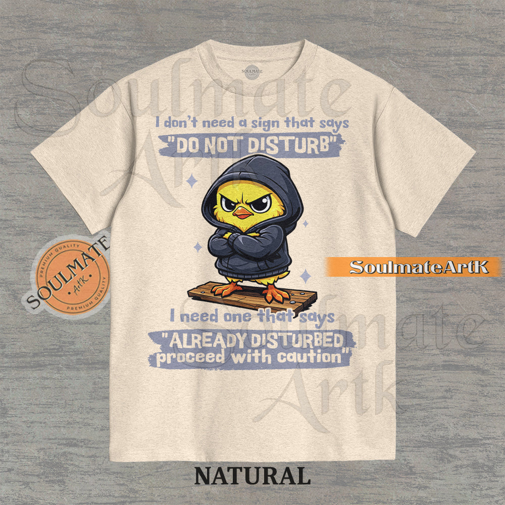 A funny t-shirt featuring a cute baby chick wearing a hoodie with a grumpy expression. The text reads "I Don't Need A Sign That Says Do Not Disturb I Need One That Says Already Disturbed Proceed With Caution."