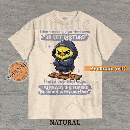 A funny t-shirt featuring a cute baby chick wearing a hoodie with a grumpy expression. The text reads "I Don't Need A Sign That Says Do Not Disturb I Need One That Says Already Disturbed Proceed With Caution."