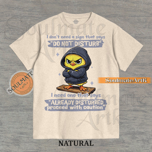 A funny t-shirt featuring a cute baby chick wearing a hoodie with a grumpy expression. The text reads "I Don't Need A Sign That Says Do Not Disturb I Need One That Says Already Disturbed Proceed With Caution."