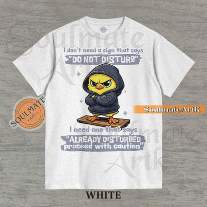 A funny t-shirt featuring a cute baby chick wearing a hoodie with a grumpy expression. The text reads "I Don't Need A Sign That Says Do Not Disturb I Need One That Says Already Disturbed Proceed With Caution."