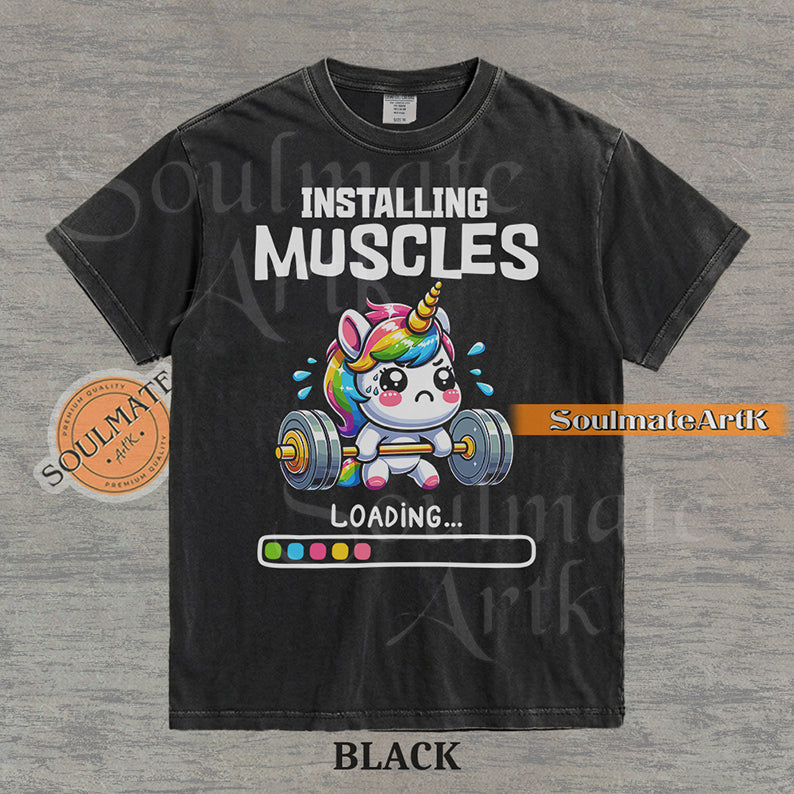 Cute cartoon unicorn lifting a heavy barbell with a loading bar and text reading Installing Muscles on a washed black shirt.