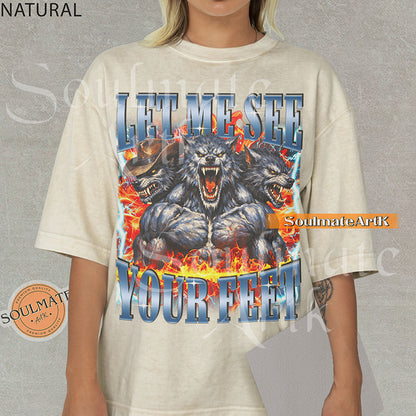 Graphic of three muscular werewolves surrounded by fire and lightning with bold blue text reading LET ME SEE YOUR FEET on a natural/ivory shirt.