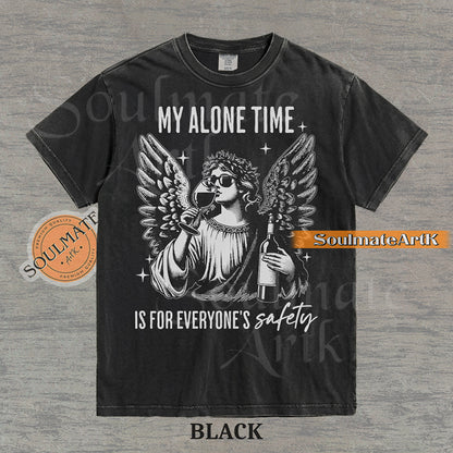Vintage-style engraving of an angel wearing sunglasses and holding a wine bottle/glass with text reading My Alone Time Is For Everyone's Safety on a washed black t-shirt.