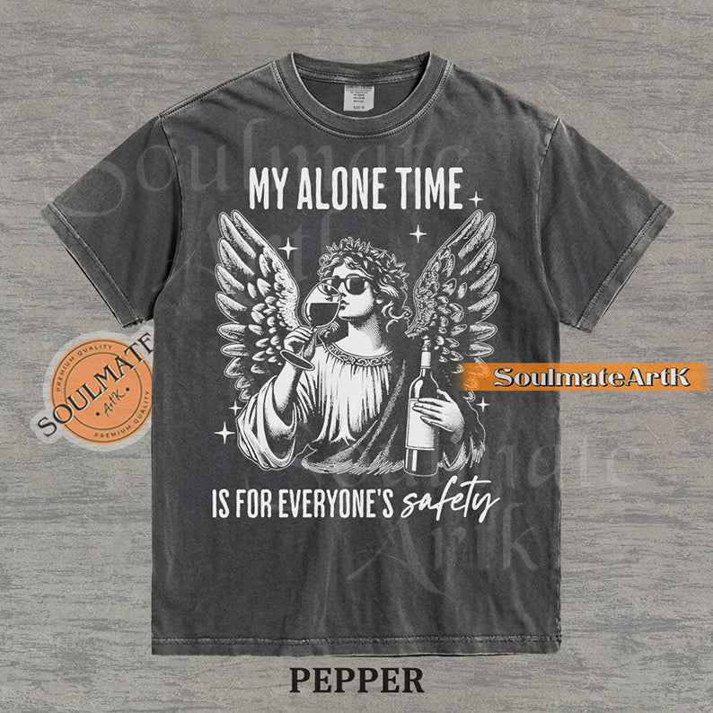 Vintage-style engraving of an angel wearing sunglasses and holding a wine bottle/glass with text reading My Alone Time Is For Everyone's Safety on a washed pepper t-shirt.