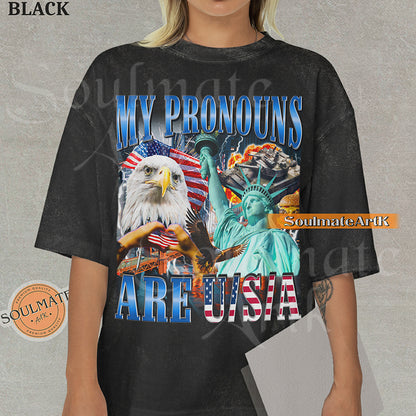 Patriotic collage featuring a bald eagle, Statue of Liberty, and American flags with bold blue and red text on a washed black shirt.