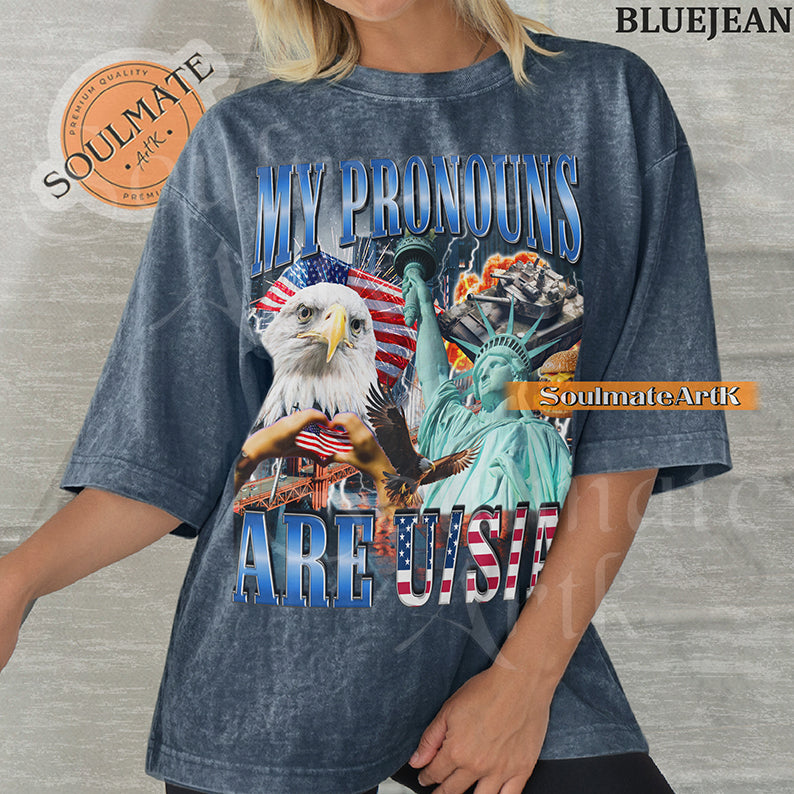 Patriotic collage featuring a bald eagle, Statue of Liberty, and American flags with bold blue and red text on a washed bluejean shirt.