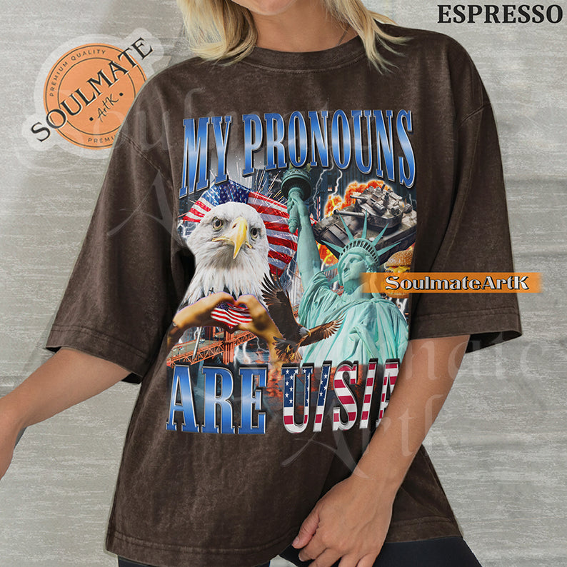 Patriotic collage featuring a bald eagle, Statue of Liberty, and American flags with bold blue and red text on a washed espresso shirt.
