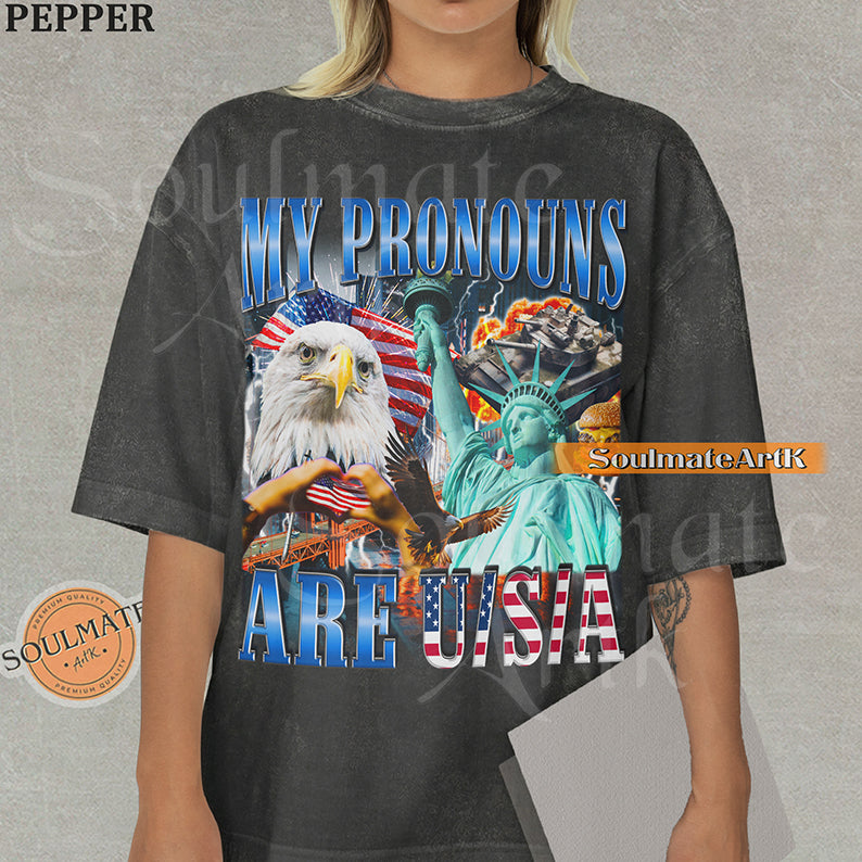 Patriotic collage featuring a bald eagle, Statue of Liberty, and American flags with bold blue and red text on a washed pepper shirt.
