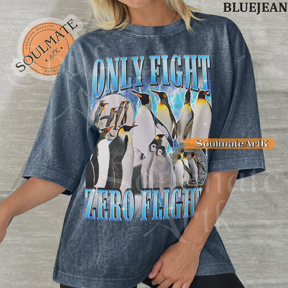 Graphic collage of emperor penguins and chicks with blue lightning and bold metallic text reading ONLY FIGHT ZERO FLIGHT on a washed bluejean t-shirt.