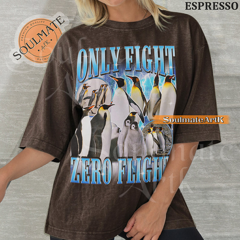 Graphic collage of emperor penguins and chicks with blue lightning and bold metallic text reading ONLY FIGHT ZERO FLIGHT on a washed espresso t-shirt.