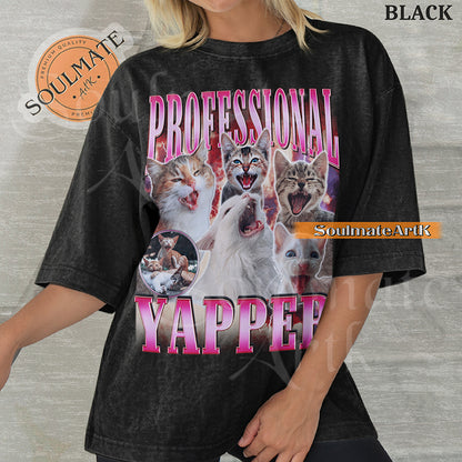 Maximalist vintage-style graphic of multiple kittens meowing with red lightning and pink metallic text reading Professional Yapper on a black Comfort Colors t-shirt.