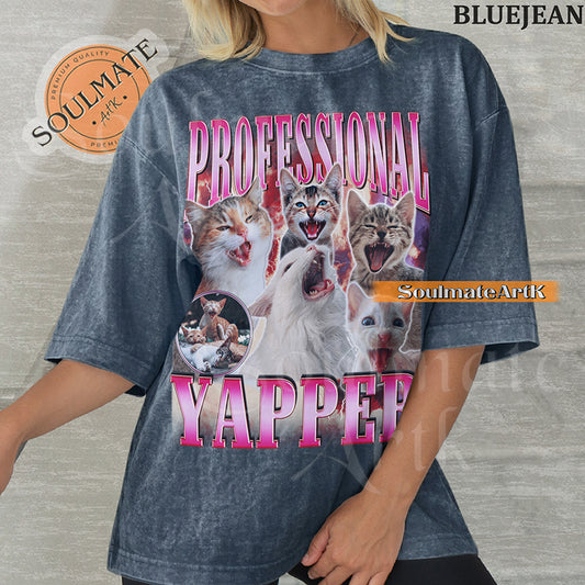 Maximalist vintage-style graphic of multiple kittens meowing with red lightning and pink metallic text reading Professional Yapper on a Blue Jean Comfort Colors t-shirt.