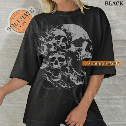 Graphic featuring three detailed screaming skulls in a monochrome illustrative style on a washed black t-shirt.