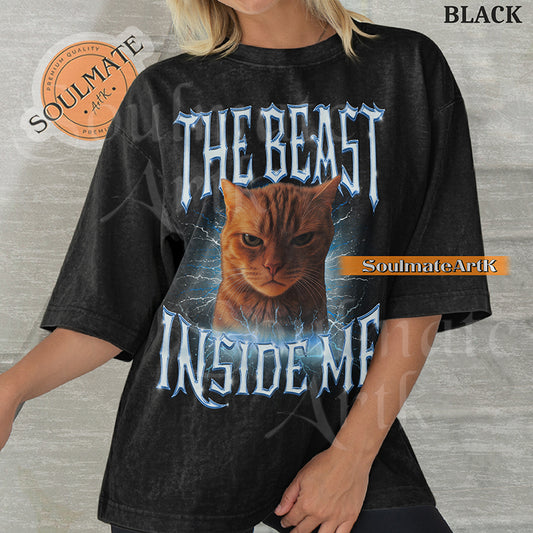 Graphic of an intense orange cat surrounded by blue lightning with bold metallic text reading THE BEAST INSIDE ME on a washed black shirt.