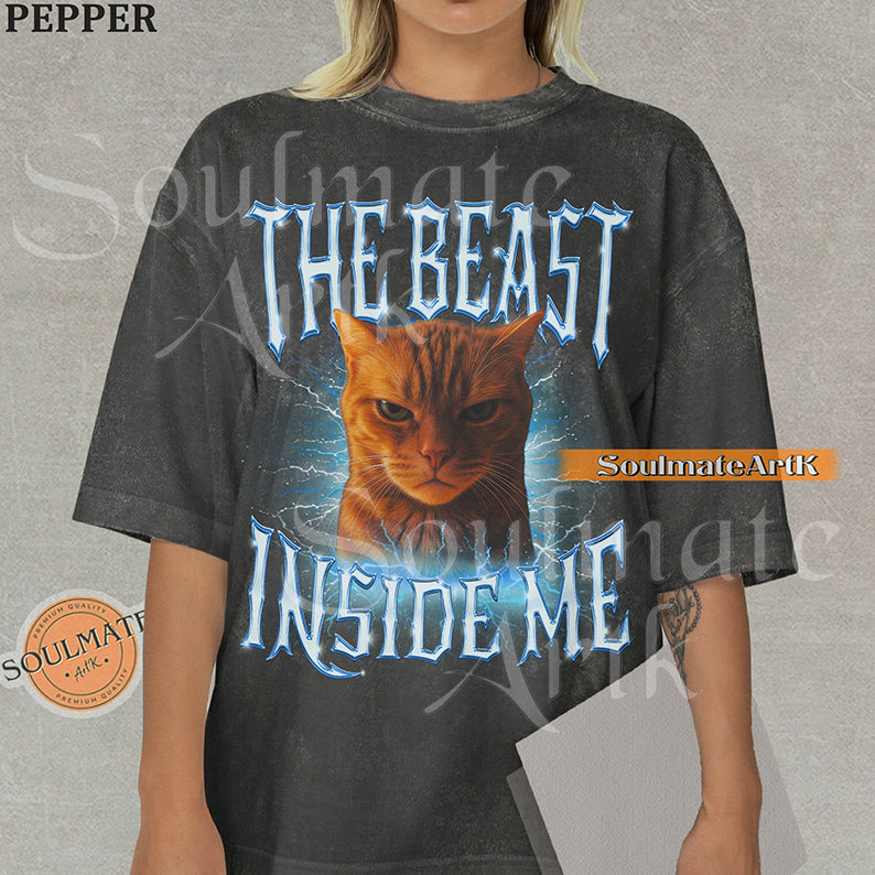 Graphic of an intense orange cat surrounded by blue lightning with bold metallic text reading THE BEAST INSIDE ME on a washed pepper shirt.