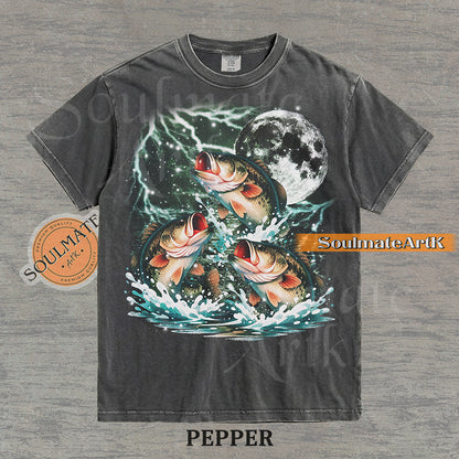 Collage of three bass fish jumping out of water in front of a glowing moon and lightning on a washed pepper shirt.