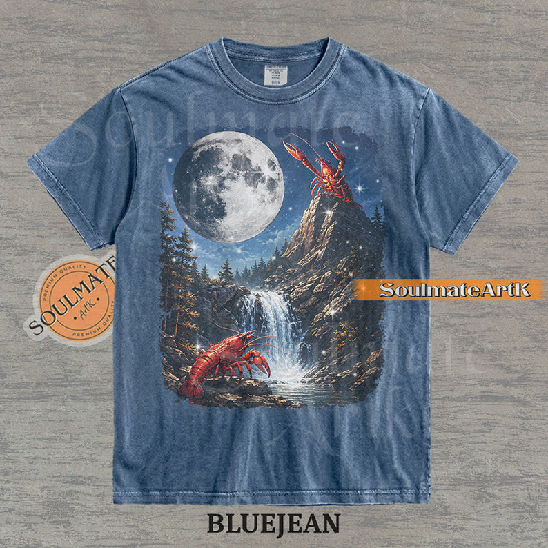 Graphic of crawfish on a mountain peak and by a waterfall under a giant full moon on a washed bluejean shirt.