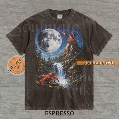 Graphic of crawfish on a mountain peak and by a waterfall under a giant full moon on a washed espresso shirt.