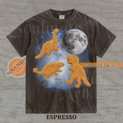 Vintage-style graphic of three golden dinosaur nuggets floating in a blue space nebula with a large moon on a washed espresso t-shirt.