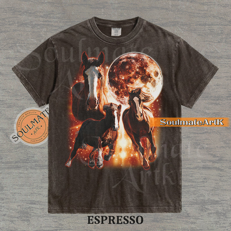 Epic celestial graphic of three horses galloping in front of a giant fiery moon and orange stardust on a washed espresso Comfort Colors t-shirt.