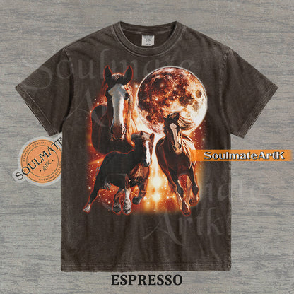 Epic celestial graphic of three horses galloping in front of a giant fiery moon and orange stardust on a washed espresso Comfort Colors t-shirt.